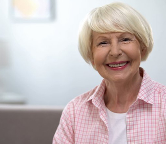Woman in pink blouse with dentures in Aurora 