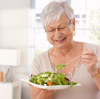 Woman eating a salad with dentures 