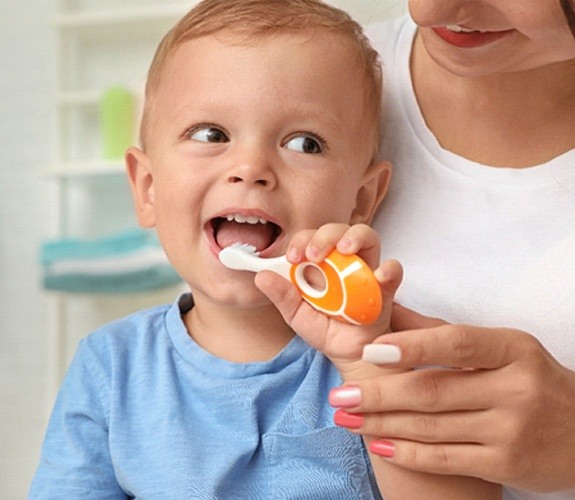 Little boy brushing teeth with pink toothbrush