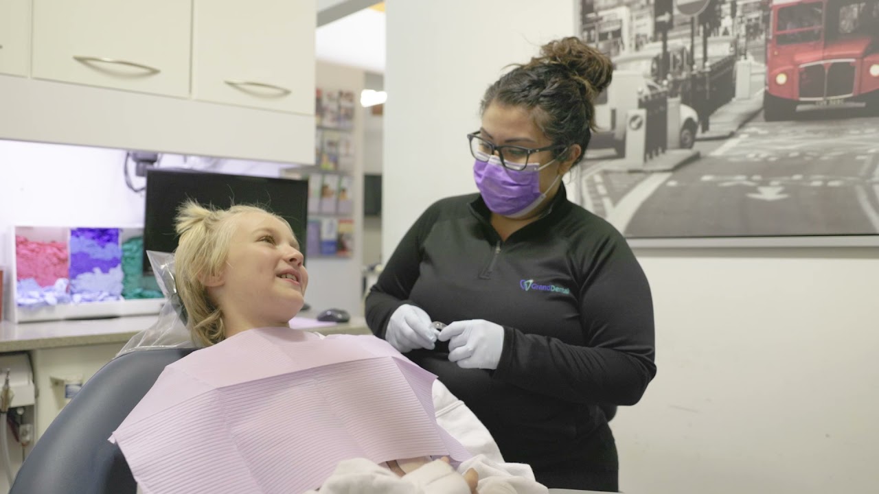 Daughter kissing mother on cheek in Aurora dental waiting room