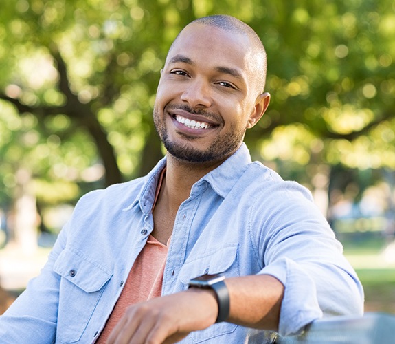 man smiling and sitting on bench