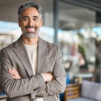 A middle-aged man smiling while wearing dentures 