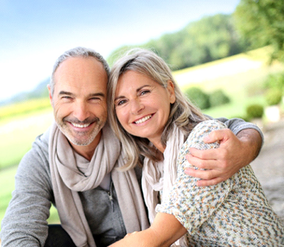 Couple smiling after cost of dentures in Aurora