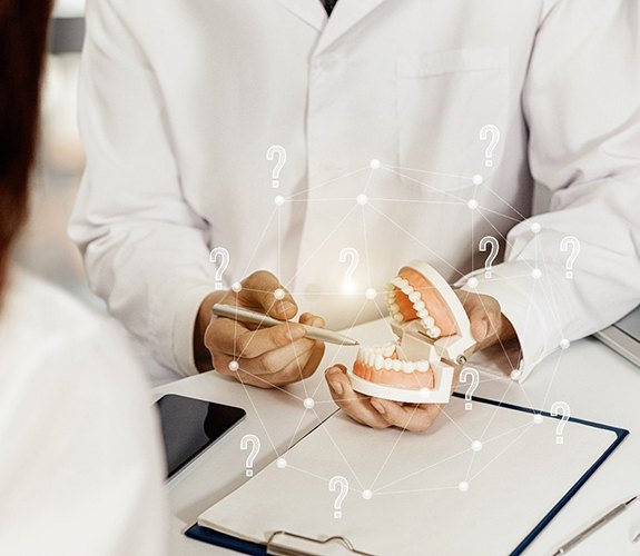 Emergency dentist in Aurora holding tooth mold 