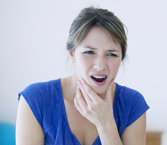 woman holding jaw in pain