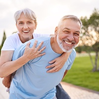 Happy middle-aged couple wearing dental implants