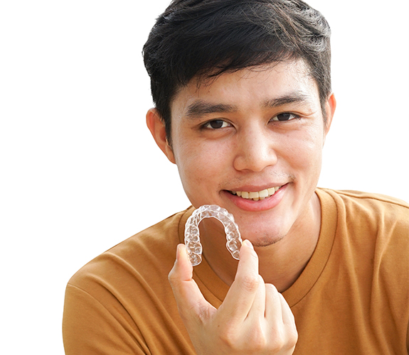 teen boy holding Clear Aligners tray