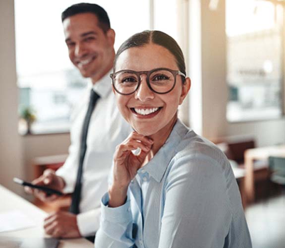 Woman with glasses smiling with tooth-colored fillings in Aurora, IL