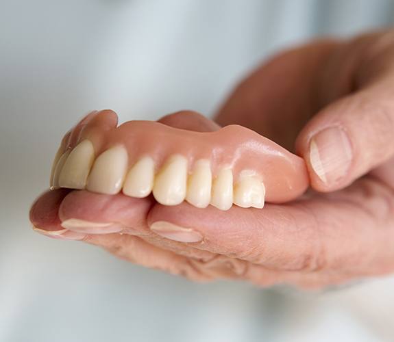 hand holding top denture