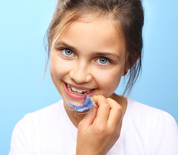 young girl putting in retainer