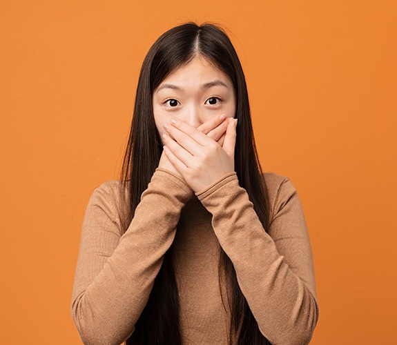 woman covering mouth with hands