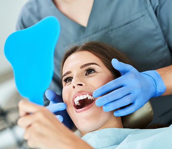 woman looking at smile in blue mirror