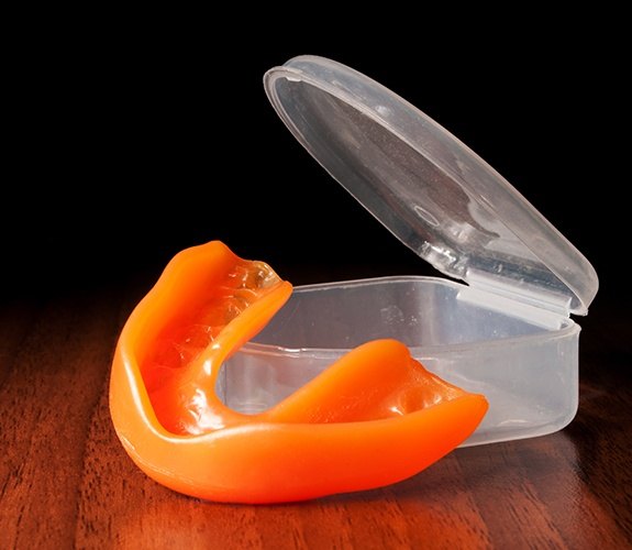 girl in boxing clothes holding mouthguard