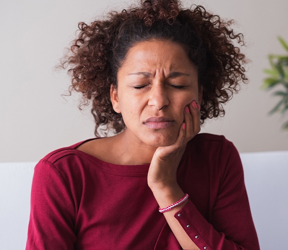 Woman holding her cheek in pain