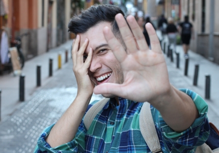 man smiling putting hand up to camera