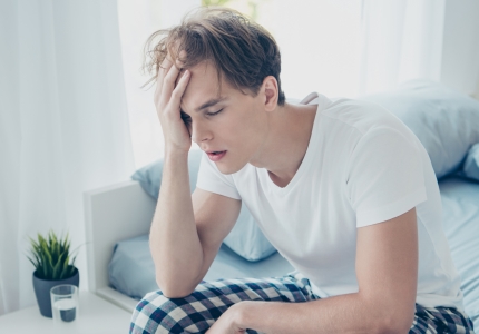 man exhausted sitting on bed