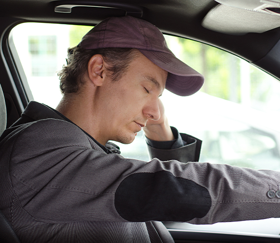 man closing eyes while driving