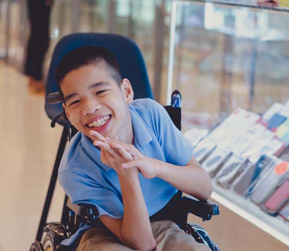 Young boy with special needs next to phone cases