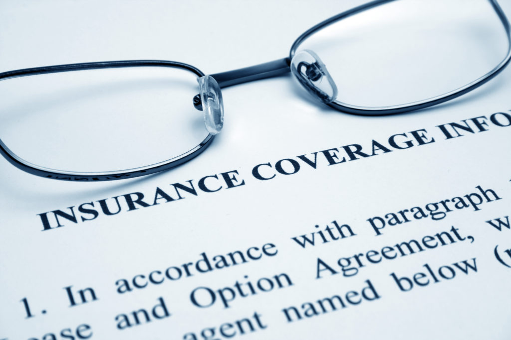 Glasses on a page detailing dental insurance coverage