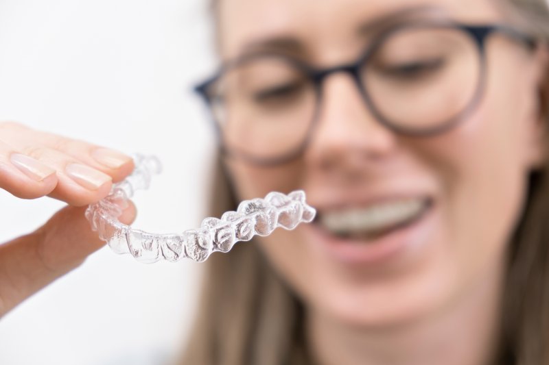 girl holding Invisalign aligner