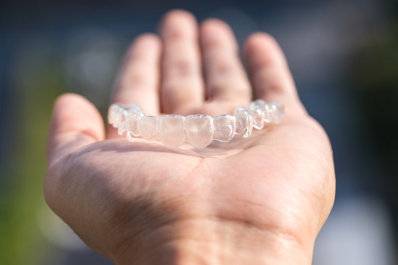 hand holding a clear aligner