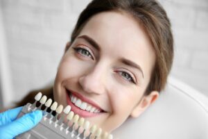 woman smiling next to a shade guide